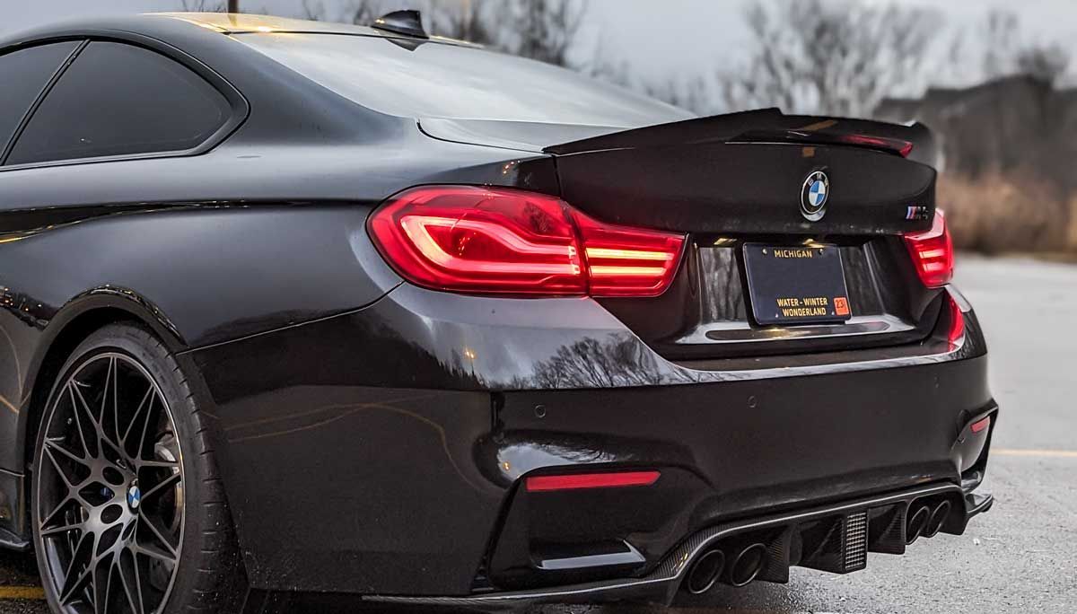 black bmw m4 with carbon fiber trunk spoiler and carbon fiber rear diffuser