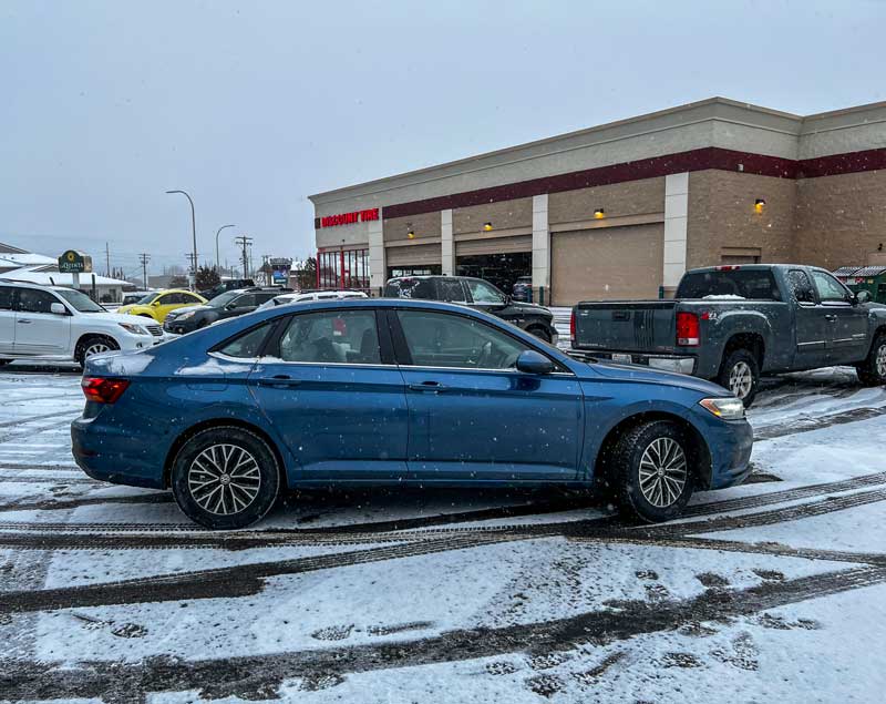 vw jetta parked next to discount tire store with blizzak ws90 tires on